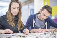 male and female looking at electronics